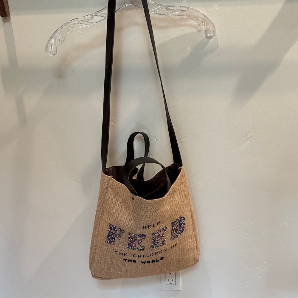 Feed the Children Crossbody Bag. Beige with multicolor beading on the front.